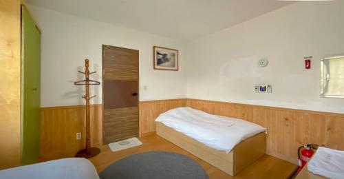 西归浦市背包客之家旅馆的小房间设有床和小浴室