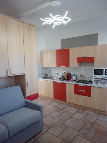 Villanova dʼAstiLovely apartment with terrace by Alterego的一间厨房,内设红色橱柜和一张沙发