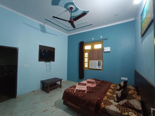 ShivpuriRatan Homestay的一间卧室设有吊扇和蓝色的墙壁。