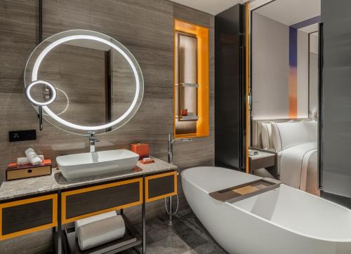 西安西安曲江希尔顿嘉悦里酒店的带浴缸、水槽和镜子的浴室