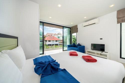 卡塔海滩3-Story Pool Villa Katahan UTK B4 just 7 min walk to Kata Beach的卧室配有白色床和蓝色弓
