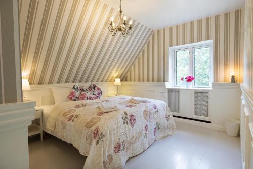 BryrupVelling Koller Hotel og Camping的一间卧室设有一张床、一个窗户和一个吊灯。