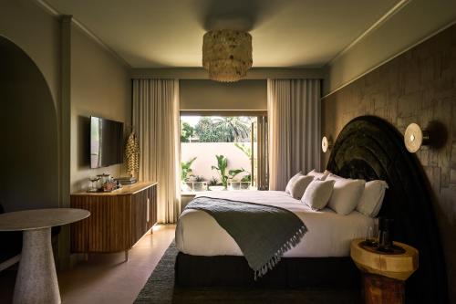 拜伦湾Swell Hotel Byron Bay - Adults Only的一间卧室设有一张大床和一个窗户。