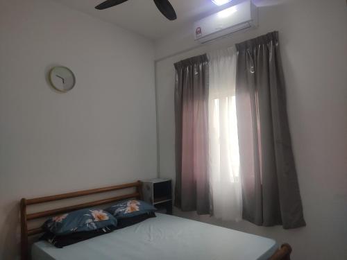 峇冬加里Hulu Yam Musliim Homestay的一间卧室配有床和带窗帘的窗户