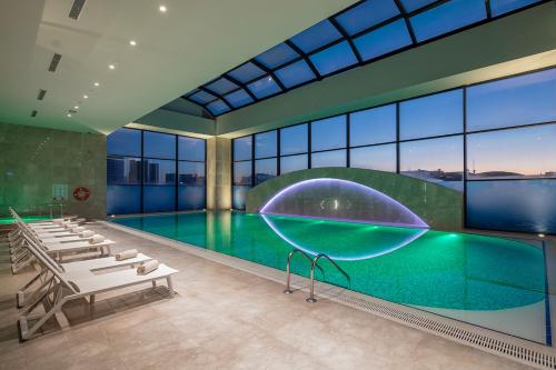 伊斯坦布尔Doubletree by Hilton Istanbul Umraniye的一个带大型玻璃墙的游泳池