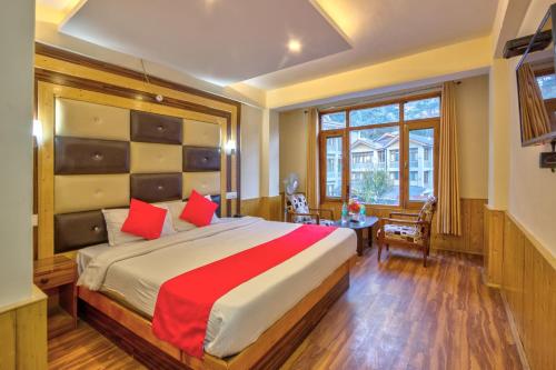 马拉里Hotel Vijayant的一间卧室配有一张带红色枕头的大床