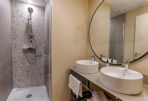 瓦讷Résidence Meublée Bellini Vannes的浴室设有2个水槽和镜子