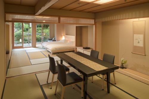 箱根强罗花坛传统日式旅馆的一间卧室配有桌椅和一张床