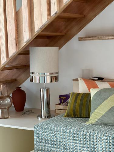 塞尼奥斯Ocean Lodge_plage Bourdaines的一间卧室配有一张床和一张桌子上的台灯