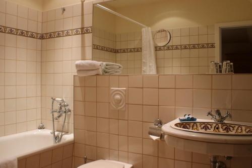 UlrichshusenHotel Schloss & Gut Ulrichshusen的带浴缸、盥洗盆和卫生间的浴室