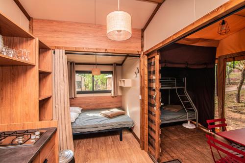 瓦瑟洛讷Camping Onlycamp de Wasselonne的一个小房子,设有一间卧室和一张双层床