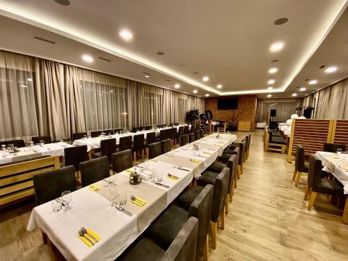 鲁塞Комплекс Дунав的餐厅的一排餐桌,配有白色桌布