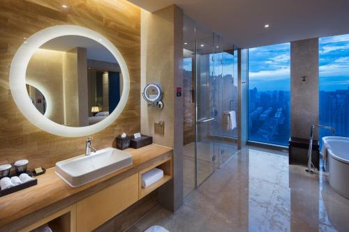 杭州杭州和达希尔顿逸林酒店的一间带水槽、淋浴和镜子的浴室