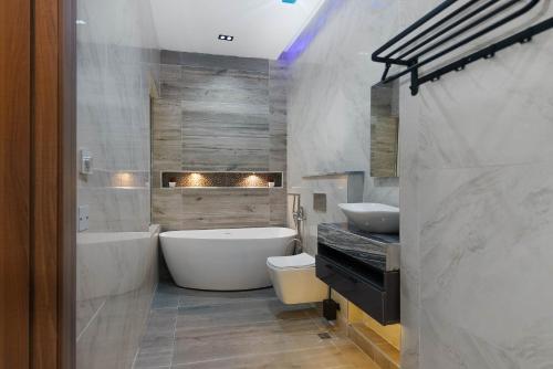 伊凯贾GTA HOTEL IKEJA的带浴缸、卫生间和盥洗盆的浴室