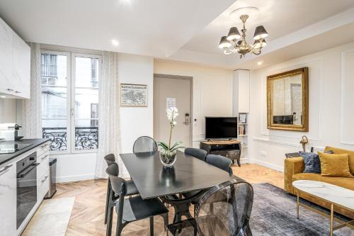巴黎卢浮宫公寓 - 沼泽的厨房以及带桌椅的起居室。