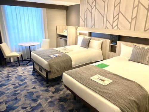 札幌札幌蒙特利埃德尔霍夫酒店的酒店客房设有两张床和一张桌子。