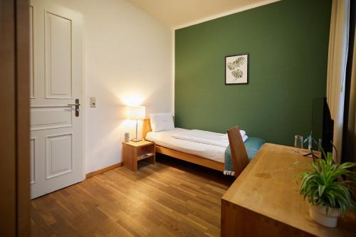 Lenzenahead burghotel的绿色的小房间,配有床和桌子