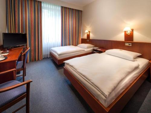 汉堡Hotel Alte Wache的酒店客房配有两张床和一张书桌