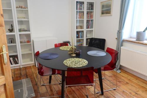 Stacija Suntaži viesnīca的一间用餐室,配有黑桌子和红色椅子