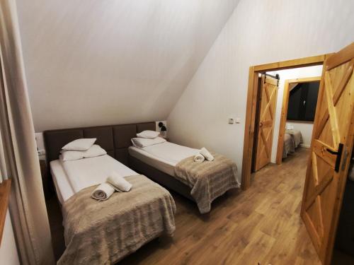 新塔尔格Przystanek Gorce的小型客房的两张床,配有镜子