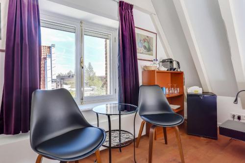 阿姆斯特丹City-centre, Canal-house, luxurious , stylish bedroom, ensuite bathroom, own entrance的窗户客房内的两把椅子和一张桌子
