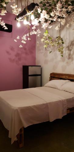 圣多明各Tus Recuerdos的卧室配有一张墙上鲜花的床