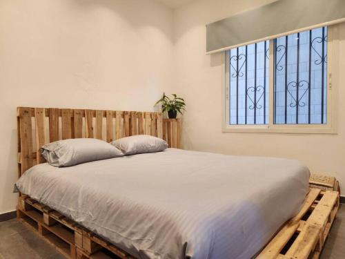 贝鲁特Charming 2BR Gemayze的一间卧室配有一张木床和窗户