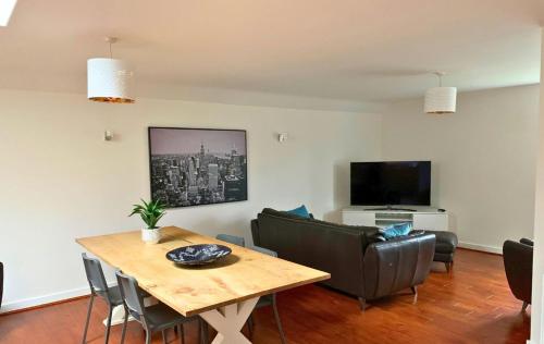 沃金厄姆Wokingham - Large 2 bedroom Apartment的客厅配有桌椅和电视。
