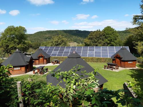 埃希特纳赫Camping Officiel Wollefsschlucht Echternach的一组配有太阳能电池板的木制建筑