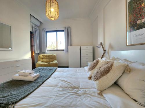 贝鲁特Chill 2Br haven Gemmayze的卧室配有一张白色大床和一把椅子