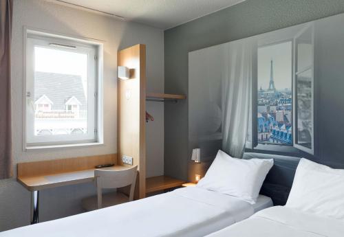 维勒班特B&B HOTEL Paris Nord Villepinte的酒店客房设有两张床和窗户。