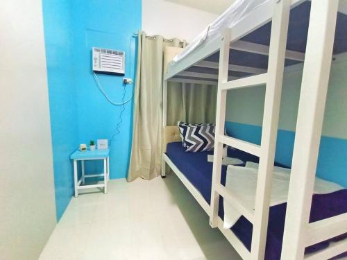 公主港Palawan Paradise Condotel 1L的一间卧室设有一张双层床和蓝色的墙壁。
