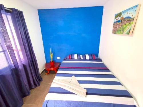 米卡Central Habitación en Minca的一间设有两张蓝色墙壁的床的房间