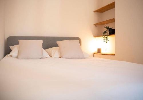 马赛Maison au cœur de l’Estaque的卧室配有白色的床和2个枕头