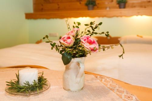鲁波尔丁Ferienwohnung Hinterreiter的一张桌子上满是粉红色玫瑰的花瓶