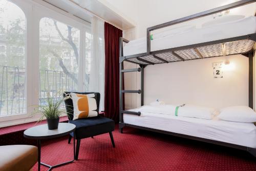 布达佩斯玛维里克旅馆及套房的一间卧室配有双层床和椅子