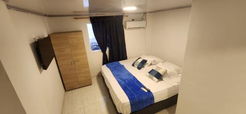 布埃纳文图拉Edificio Regata INN的一间卧室配有一张带蓝色床单和枕头的床。
