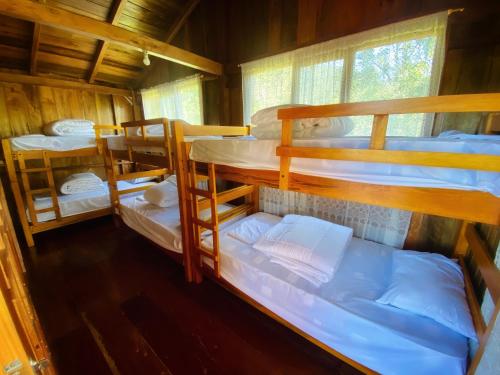 明多Inti Mindo Hostel的小屋内带4张双层床的客房