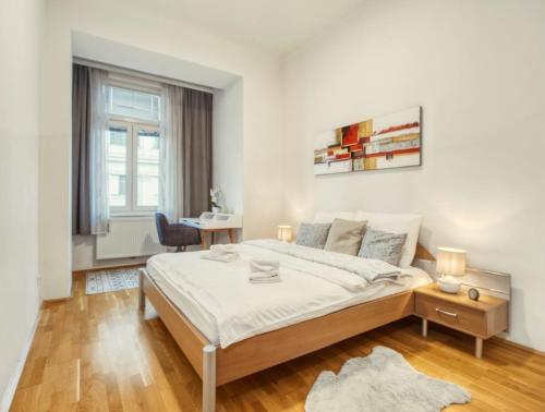 维也纳Flarent Vienna Apartments-HG的白色卧室配有床和书桌