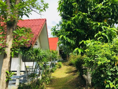Ban Tha Ling LomLungYod guesthouse的森林中一座红色屋顶的房子