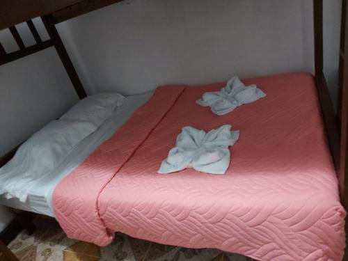 萨兰托Hostal Posada Del Corazón的粉红色的床和两条白色毛巾