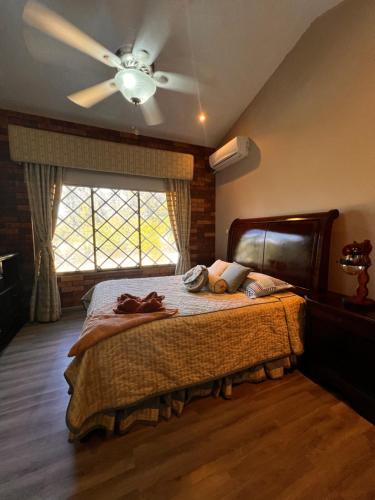 下博克特Casa familiar en Boquete的一间卧室配有一张带吊扇的床