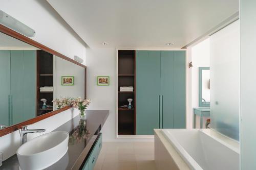 潘切Casa Home - Ocean Melody - Beach Front 3br Apartment的带浴缸、水槽和镜子的浴室