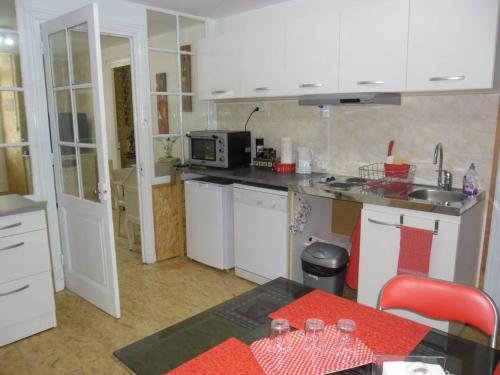 Bourg-ArgentalMeublé Bulgarana - 4 pers的厨房配有白色橱柜、水槽和桌子