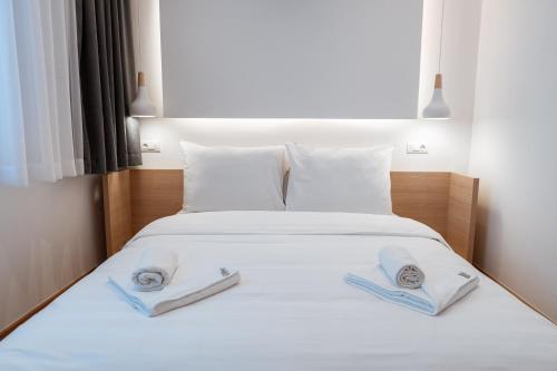 亚霍里纳Aparthotel Zlatni Javor的一间卧室配有一张床,上面有两条毛巾