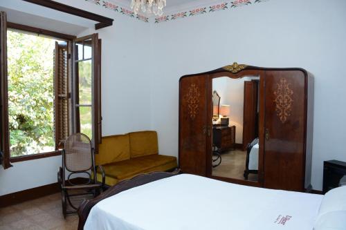 Sant Pau dʼOrdal埃尔雷契尔旅馆的一间卧室配有一张床、镜子和椅子