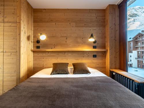 蒂涅Apartment Le Pramecou - Val Claret-8 by Interhome的卧室配有木墙内的一张床