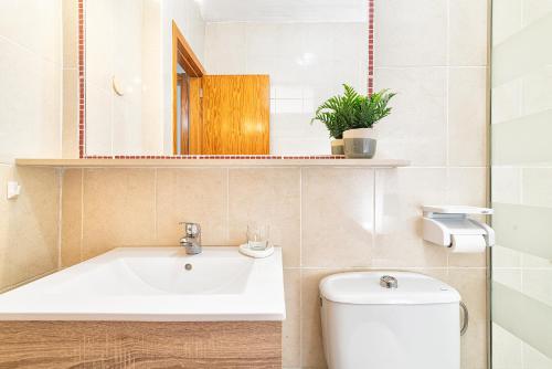 马斯帕洛马斯Bungalow Green Oasis Club的一间带水槽、卫生间和镜子的浴室