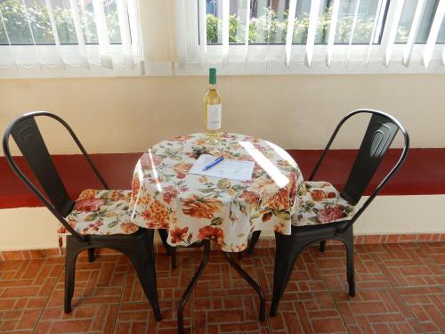 蓬塔杜帕戈Jasmine Guest Suite的一张桌子和两把椅子,上面有一瓶葡萄酒