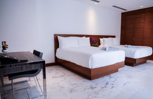 巴拿马城Hotel San Felipe的一间卧室配有两张床、一张桌子和一架钢琴